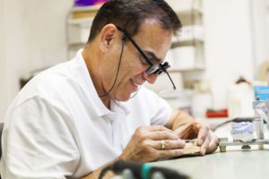 Zahntechniker-Meister mit Spezialbrille bei der Arbeit